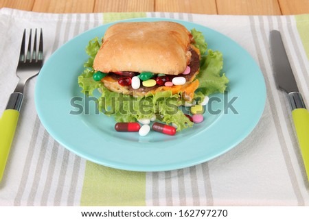 Conceptual image for nutritional care:assorted vitamins and nutritional supplements in bun. On wooden background