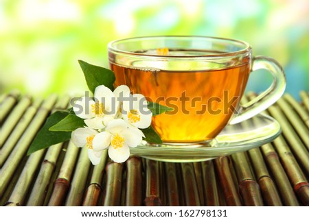 Cup of tea with jasmine, on bamboo mat, close-up