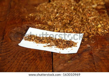 Tobacco and rolling paper, on wooden background