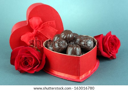 Chocolate candies in gift box, on grey background