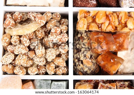 Tasty oriental sweets in wooden crate, close up