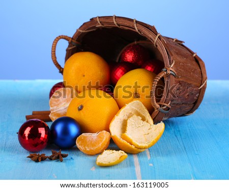 Christmas tangerines and Christmas toys in basket on blue background