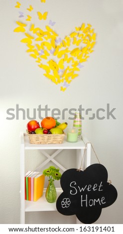 Composition of various home furnishing on white shelf on grey wall background