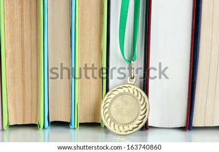 Medal for achievement in education with books close up