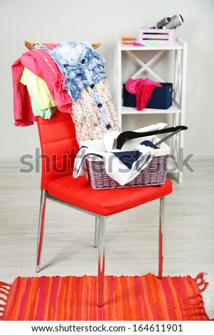 Heap of  clothes on color chair,  on gray background