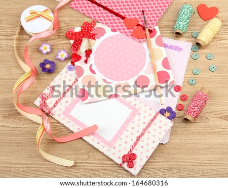 Beautiful hand made post cards and scrapbooking elements, on wooden table