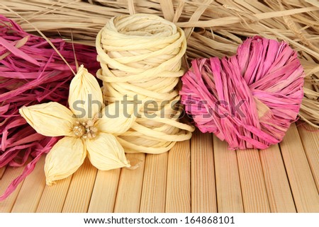 Decorative straw for hand made, flower and heart of straw, on wooden background