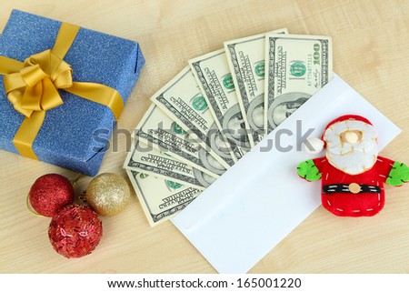 Dollar bills in envelope as gift at New year on wooden table close-up