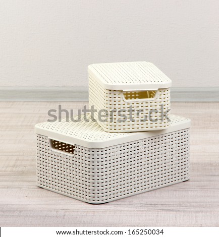 Plastic baskets for storing things in floor on room background