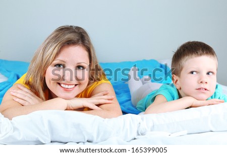 Little boy with mom lying in bed