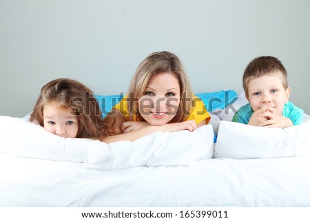 Little children with mom lying in bed