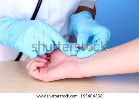vaccine injection in hand on blue background