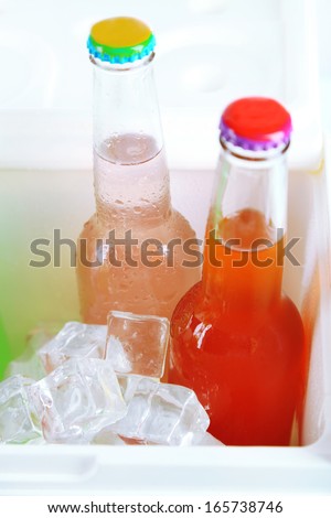 Drinks in glass bottles in mini fridge close up