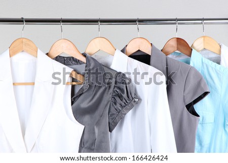 Office female clothes on hangers, on gray background