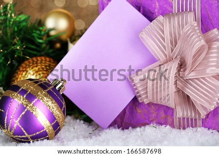 Gift boxes with blank label and Christmas decorations on snow close up