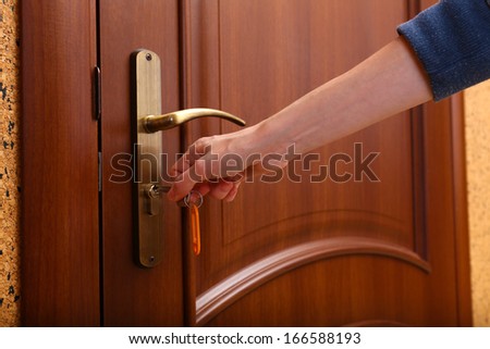 Locking up or unlocking door with key in hand