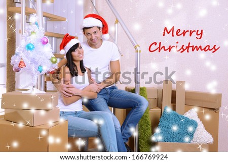 Young couple celebrating New Years in new home on stairs background