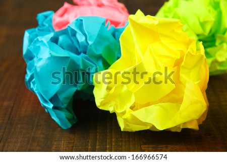 Colorful crumpled paper balls on wooden background