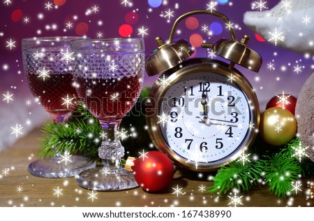 Wine glasses, retro alarm clock and Christmas decoration on bright background