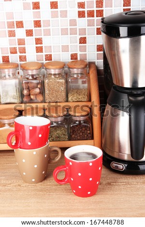 http://image.shutterstock.com/display_pic_with_logo/137002/167448788/stock-photo-cups-and-coffee-maker-in-kitchen-on-table-on-mosaic-tiles-background-167448788.jpg