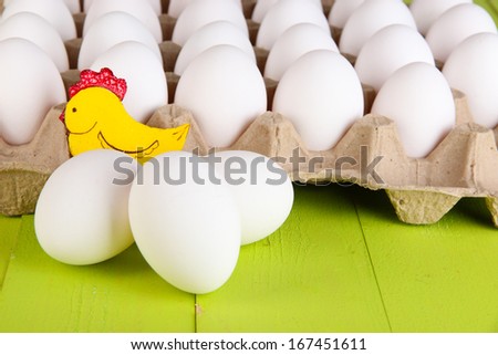 Eggs in paper tray on green wooden table close-up