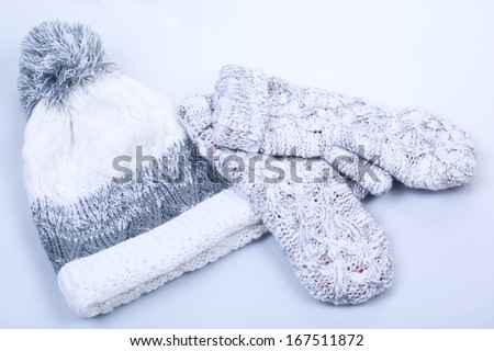 Woman knitted gloves and cap, isolated on white