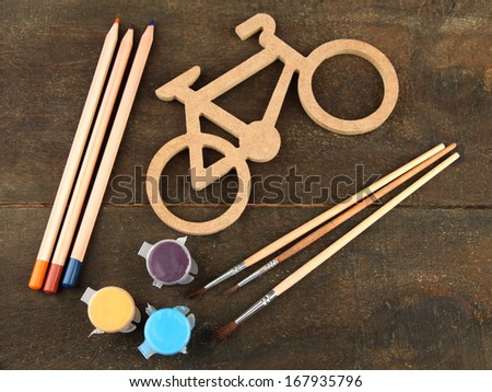 Decorative bicycle with drawing set on wooden background