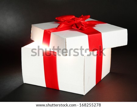 Gift box with bright light on it on dark grey background