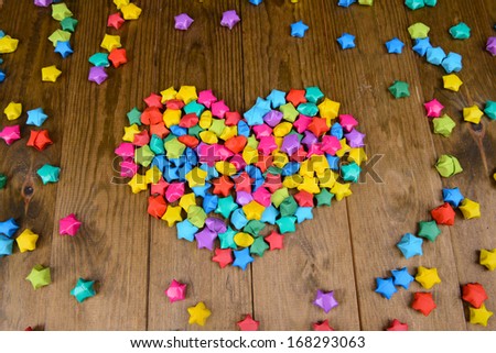 Paper stars with dreams on wooden background