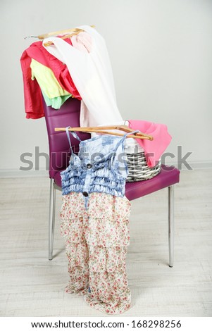 Heap of  clothes on color chair,  on gray background