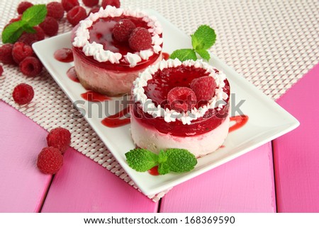Delicious berry cakes on plate on table close-up
