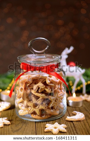 Delicious Christmas cookies in jar on table on brown background
