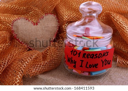 Dreams written on color  rolled paper in glass jar, on sackcloth and fabric background