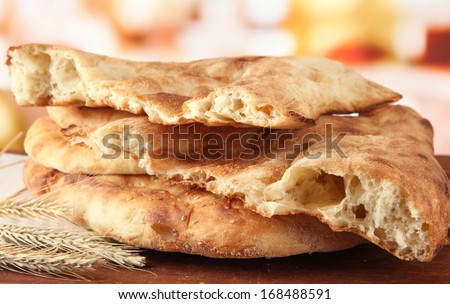 Pita breads with spikes on table on bright background
