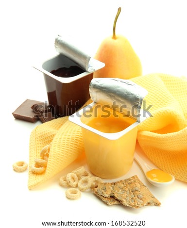 Tasty desserts in open plastic cups and fruits and flakes on napkin, isolated on white