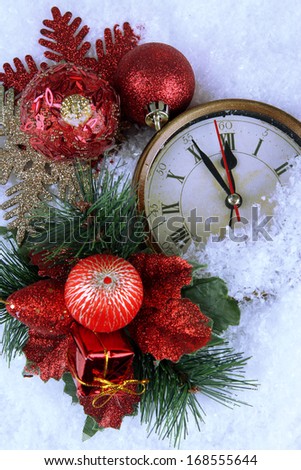 Clock and Christmas decorations under snow close up