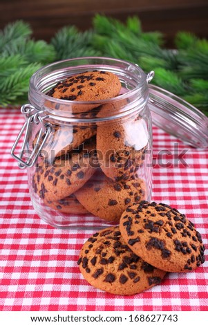 Delicious Christmas cookies in jar on table on wooden background