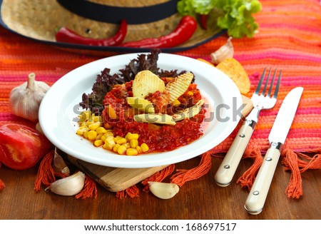 Chili Corn Carne - traditional mexican food, on white plate, on napkin, on wooden background