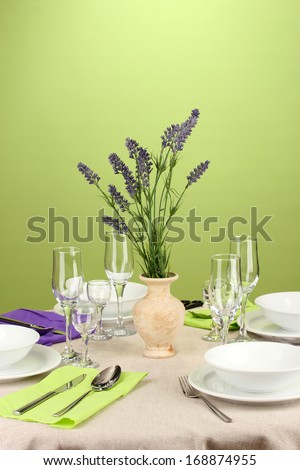 Table setting in violet and green tones on color  background