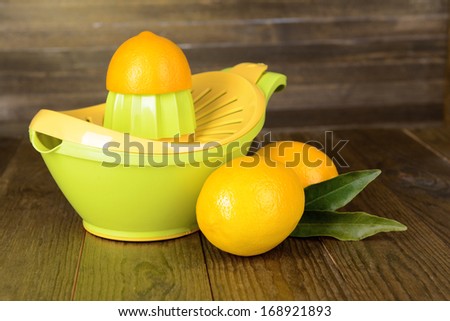 Citrus press and lemons on table on wooden background