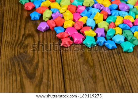Paper stars with dreams on wooden background