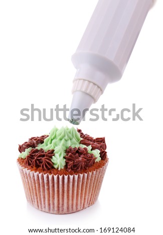 Confectioner decorating tasty cupcake with butter cream, isolated on white