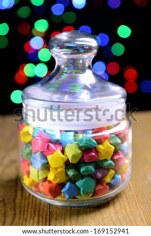 Paper stars with dreams on table on dark background