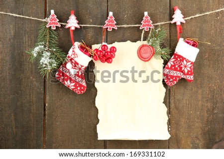 Blank sheet with Christmas decor hanging on grey wooden wall