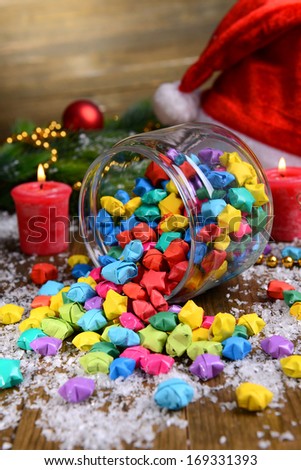 Paper stars with dreams in jar on table on wooden background