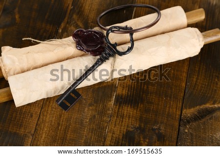 Antique keys and scroll, on wooden background