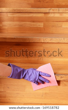 Female hand in rubber glove cleaning staircase