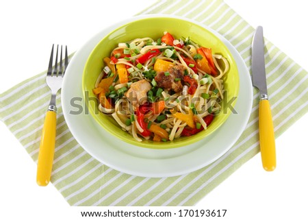 Noodles with vegetables on plate on napkin isolated on white