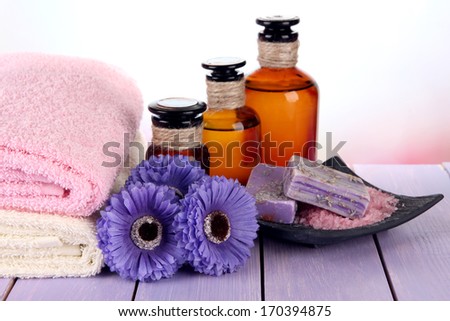 Beautiful spa setting with flowers on wooden table on bright background