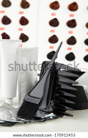 Hair dye kit on board with hair samples of different colors background